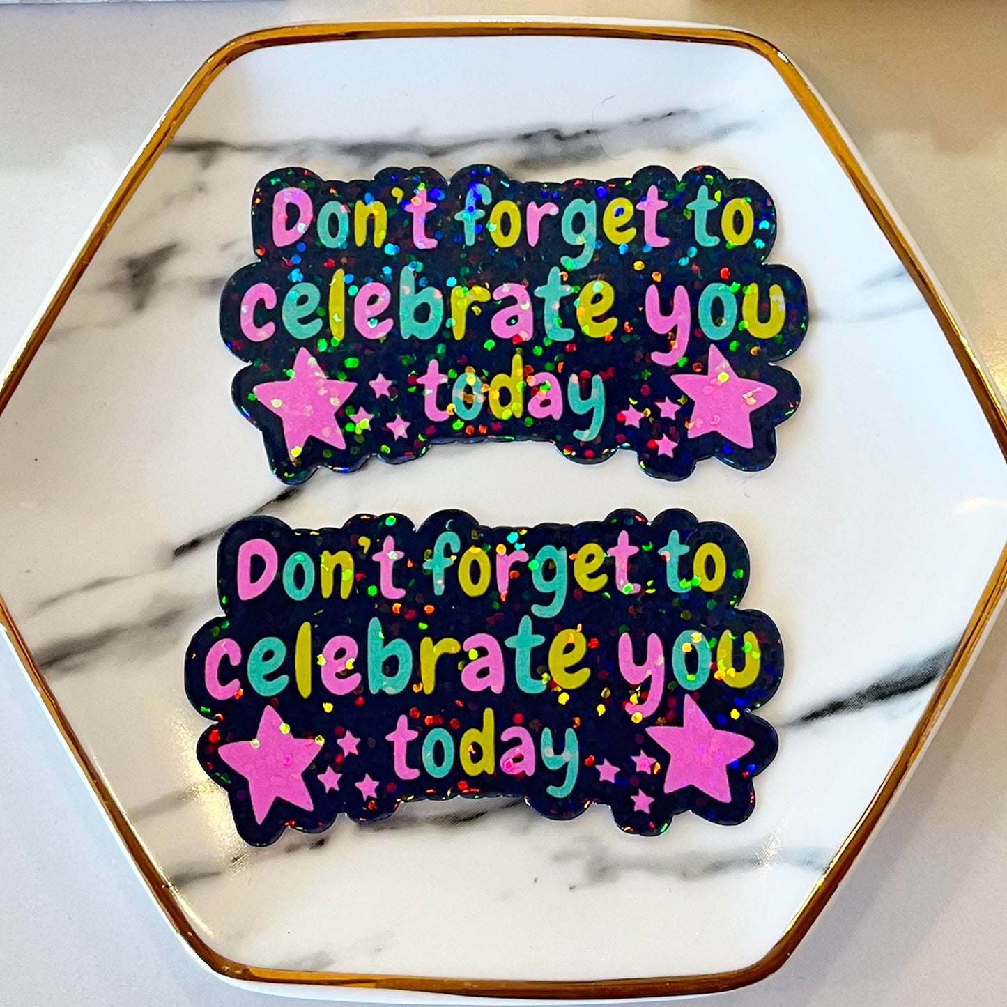 Two celeberate stickers in dish highlighting holographic finish