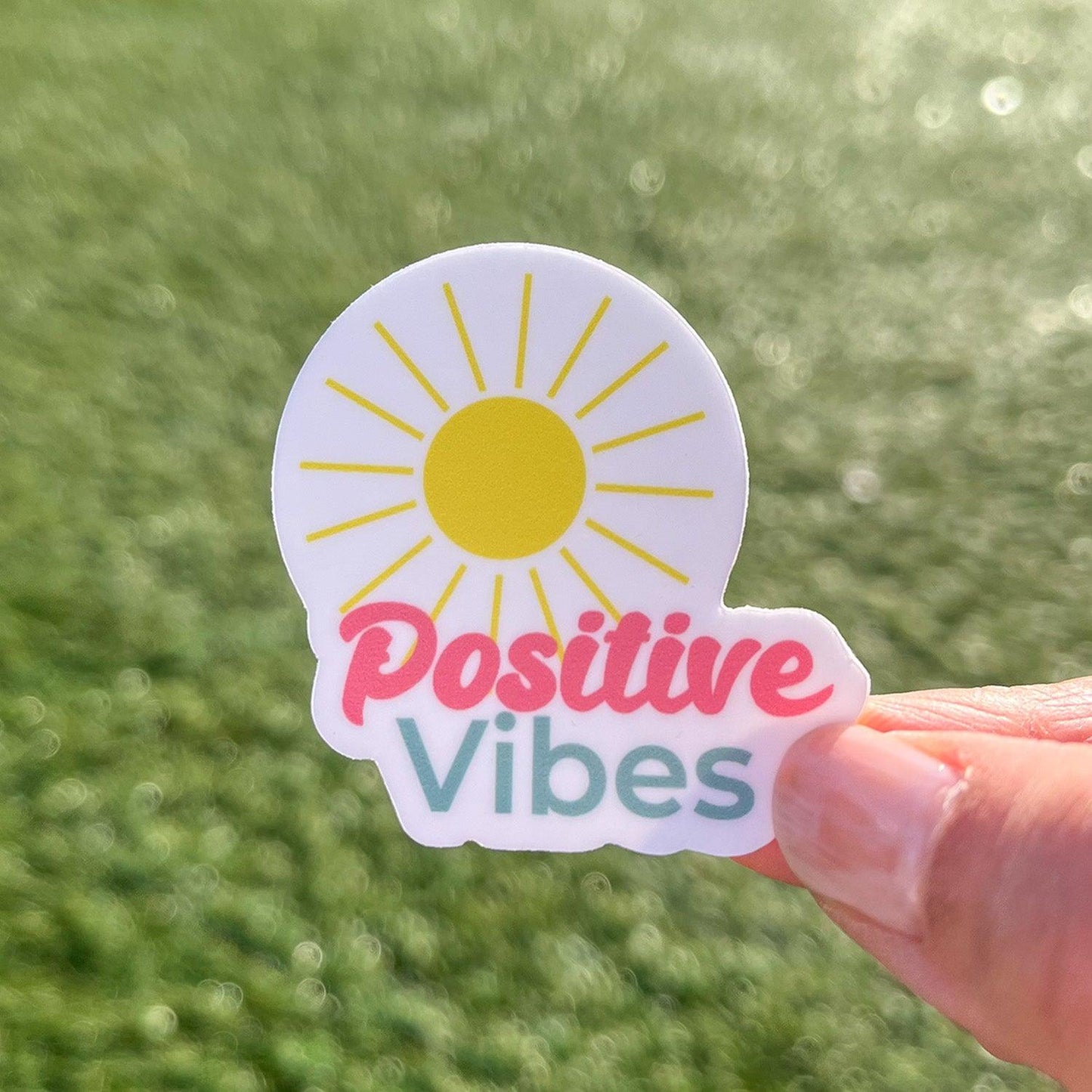 Positive Vibes sticker with grass and sunshine in the background