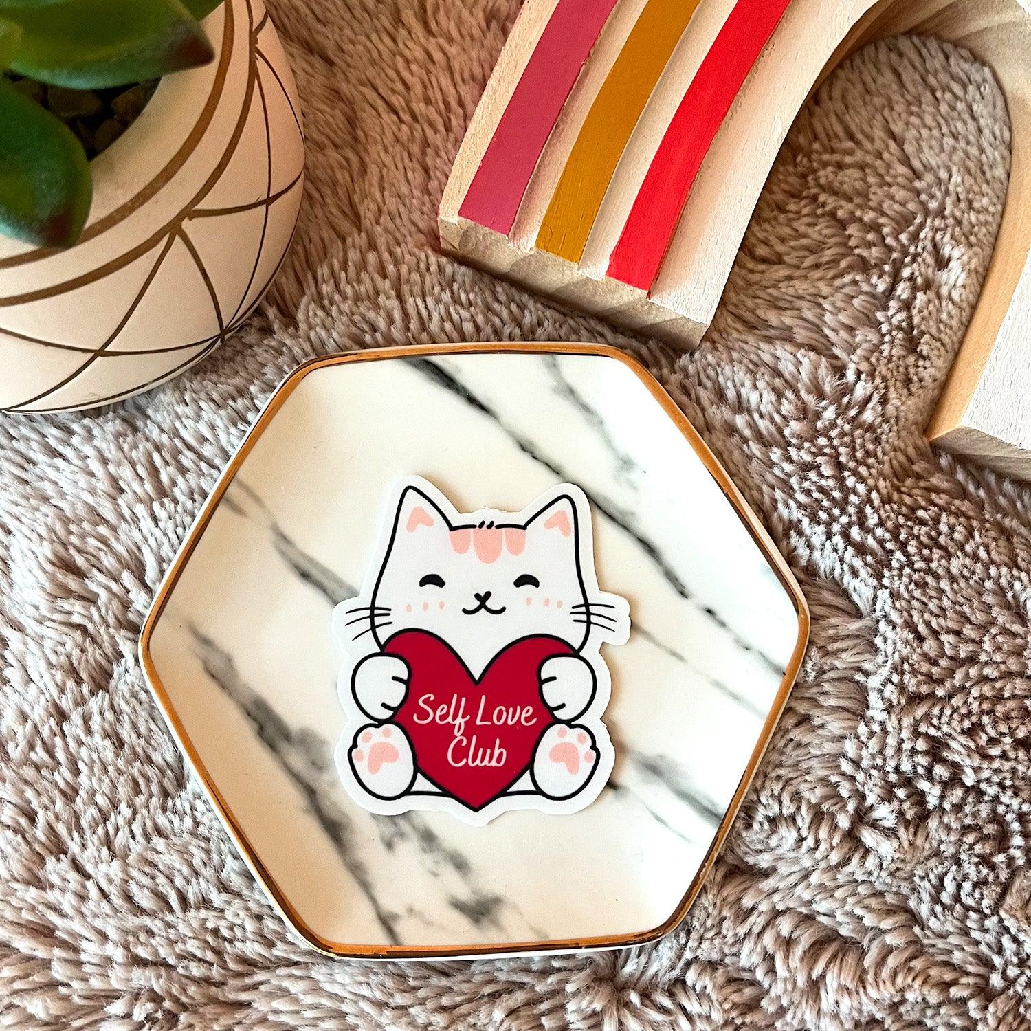 Self Love Club cat sticker shown on a dish