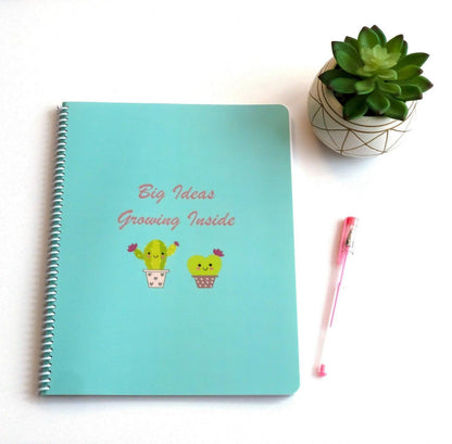 Big Ideas Notebook flat lay features adorable cacti on a blue background with phrase Big Ideas Growing Inside. 