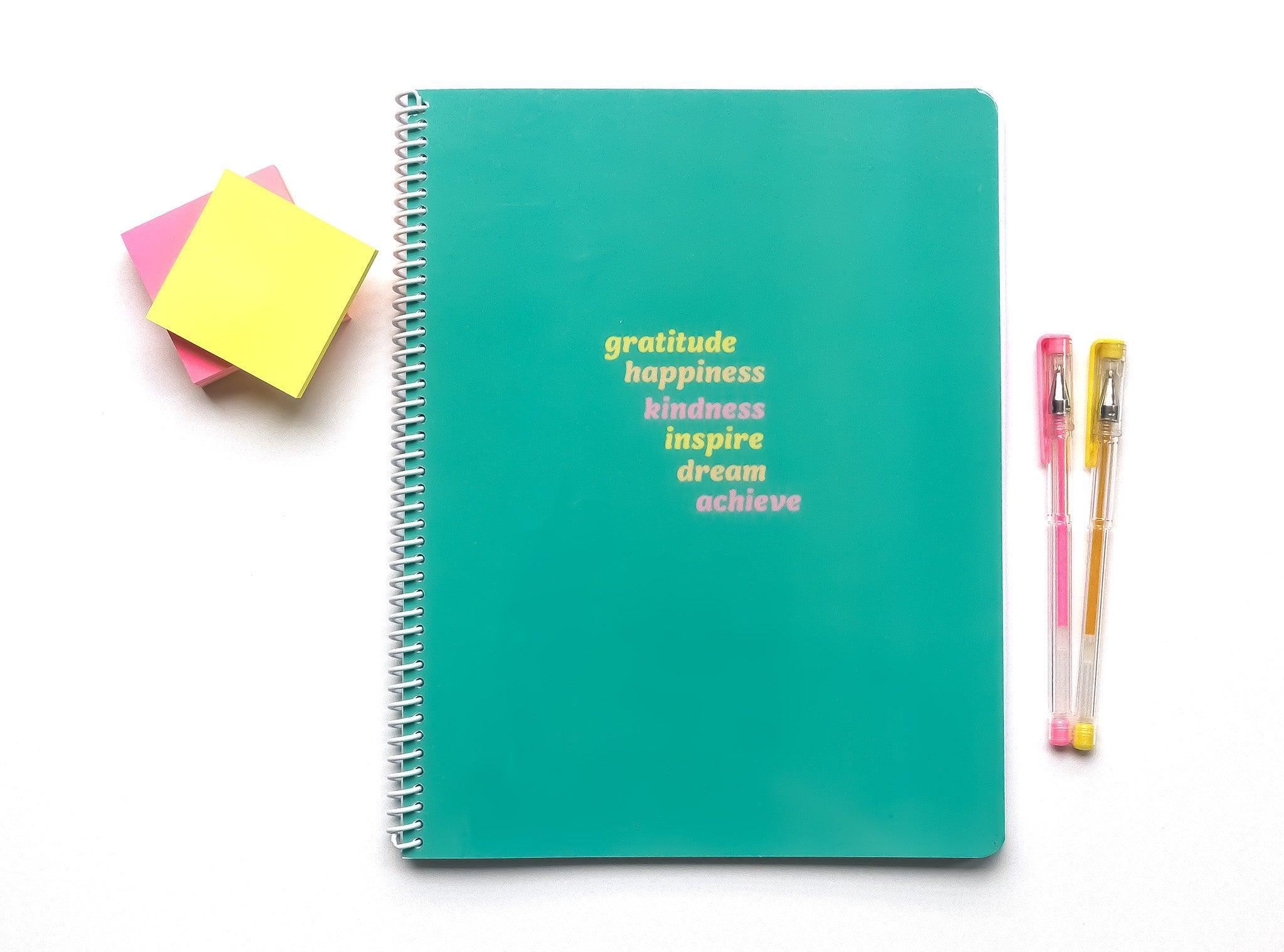 Get Inspired Notebook flat lay - cover features inspirational words like gratitude, happiness, kindness, inspire, dream, and achieve