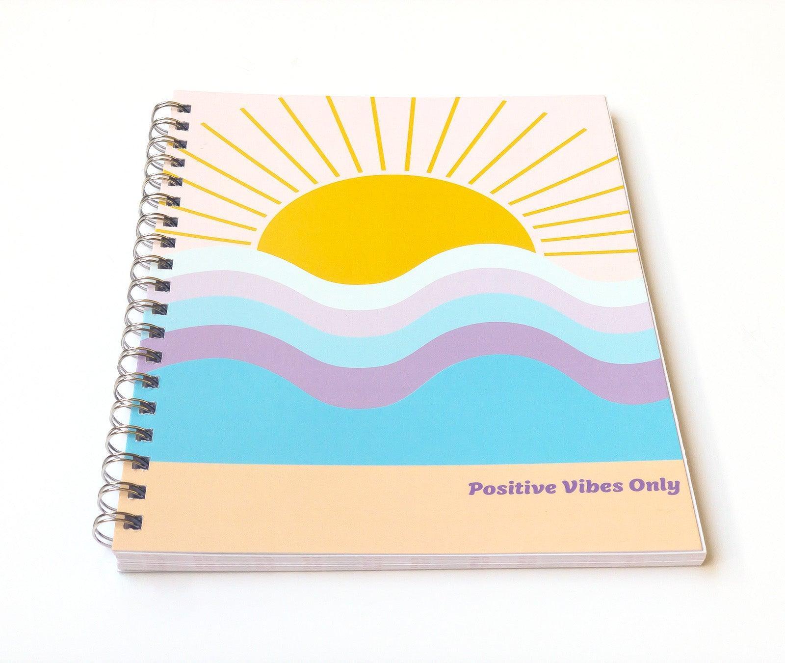 Front cover featuring sun over the horizon at the beach. Positive Vibes Only phrase in purple.